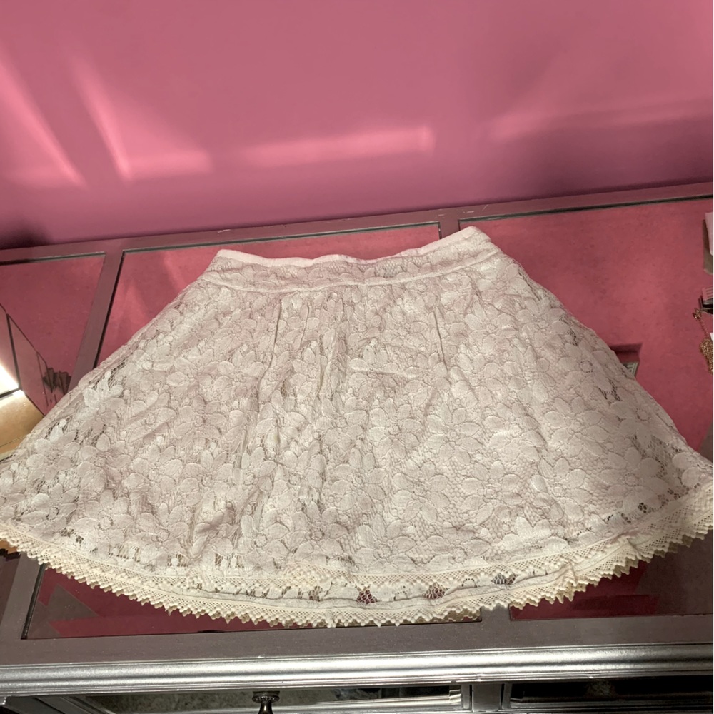 Cream colored lace mini skirt. Super cute flower and lace detail.